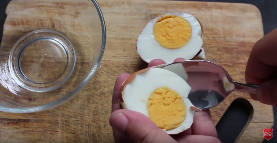 殻付きで半分に切った卵の殻をスプーンでむく